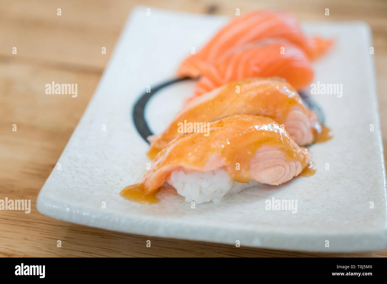 Portrait gravé de saumon top avec mayo en plaque. Nigiri sushi japonais sains Aburi style avec le riz et le poisson dans l'alimentation japonaise restaurant. Banque D'Images
