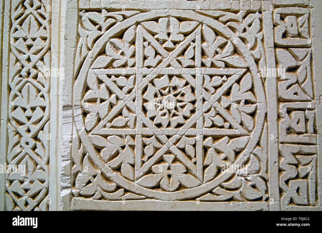 Libre d'un motif géométrique islamique sculptés en pierre de couleur claire (une étoile à l'intérieur d'un cercle) avec la calligraphie sur le côté droit. Banque D'Images