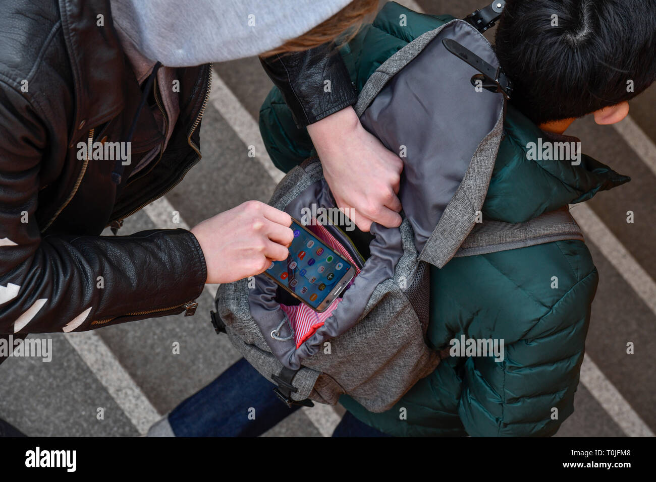 Le vol d'un téléphone mobile à partir d'un sac à dos, l'activité criminelle de la rue, mettre photo, Diebstahl aus einem von Handys, sac à dos, Straßenkriminalität gestellt Banque D'Images