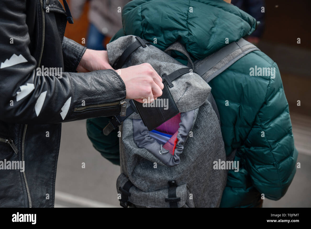 Le vol d'un porte-monnaie à partir d'un sac à dos, l'activité criminelle de la rue, mettre photo, Diebstahl aus einem von Geldbörse, sac à dos, geste Straßenkriminalität Banque D'Images