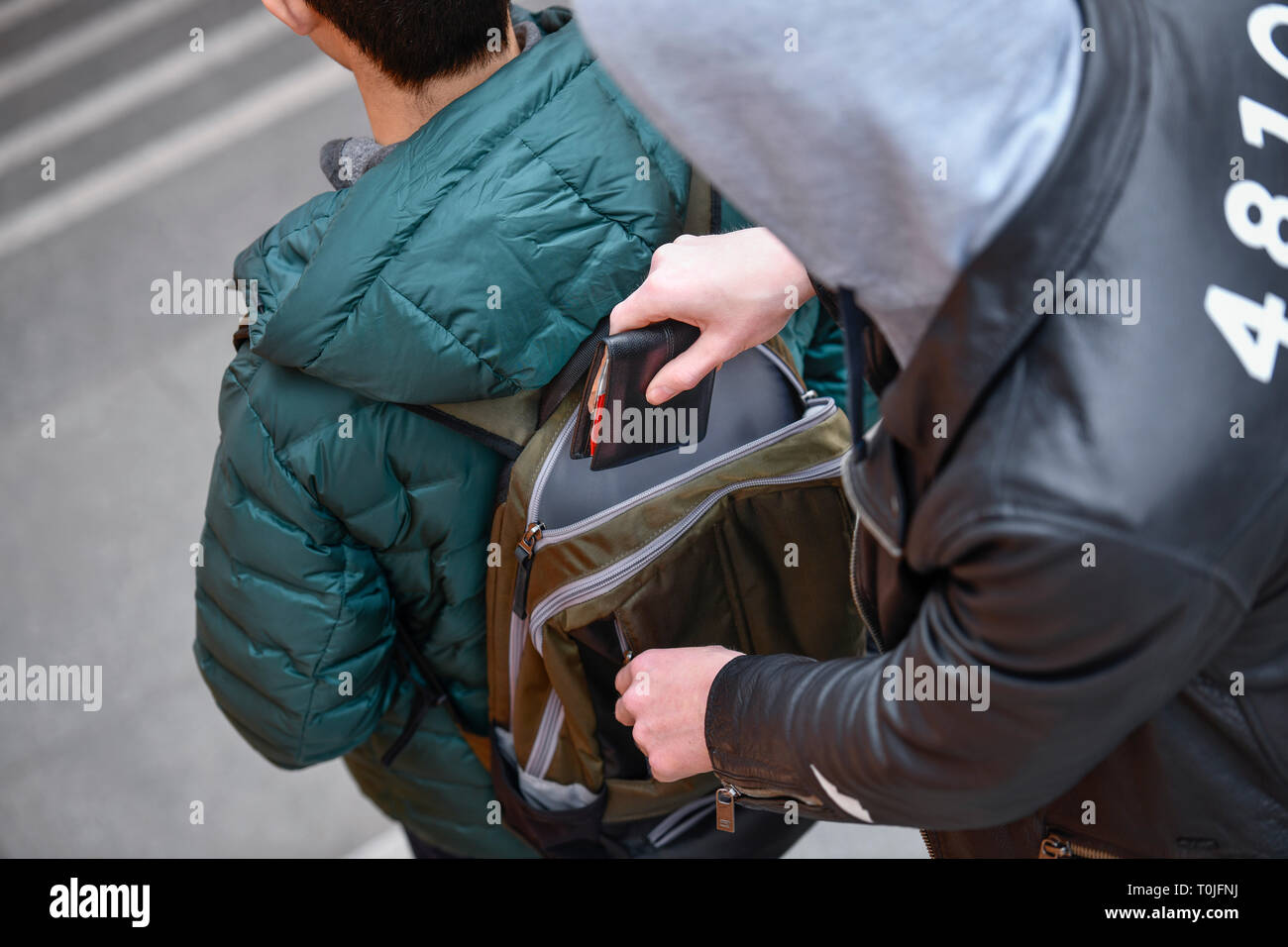 Le vol d'un porte-monnaie à partir d'un sac à dos, l'activité criminelle de la rue, mettre photo, Diebstahl aus einem von Geldbörse, sac à dos, geste Straßenkriminalität Banque D'Images