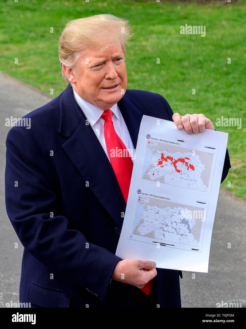 Le Président des Etats-Unis, Donald J. Trump montre une carte montrant le territoire de l'Irak/Syrie "califat physique ISIS 2017' (en haut) "Irak/Syrie ISIS Califat Physique 2019' (en bas) comme il parle aux médias qu'il quitte la pelouse Sud de la Maison Blanche à Washington, DC pour une journée à Lima, Ohio et Canton, Ohio, le mercredi 20 mars, 2019. Credit : Ron Sachs/CNP /MediaPunch Banque D'Images