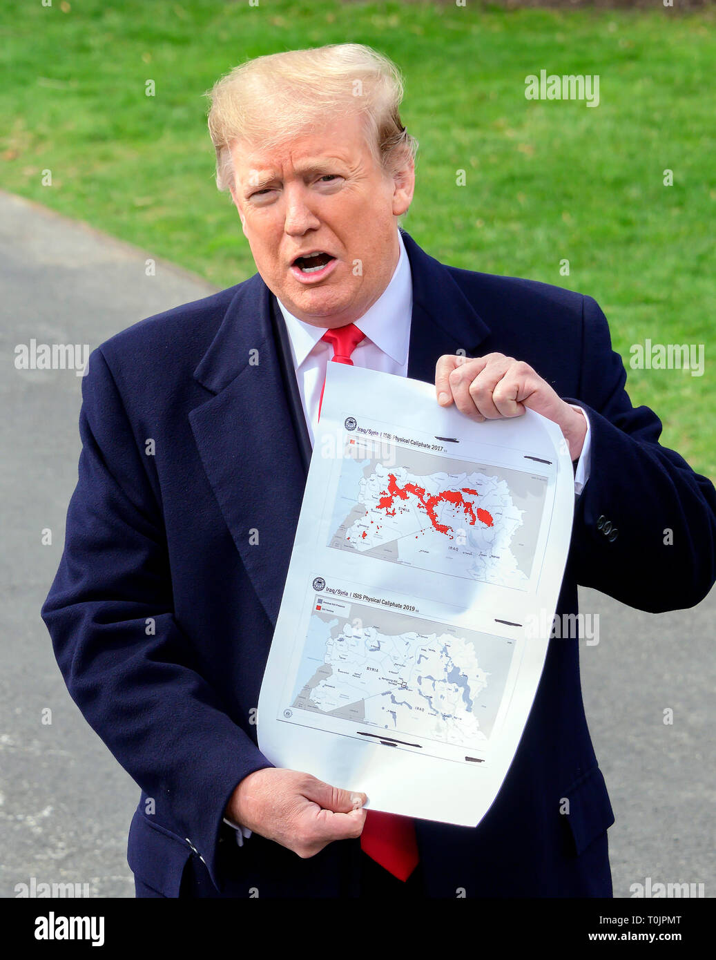 Washington, États-Unis d'Amérique. Mar 20, 2019. Le Président des Etats-Unis, Donald J. Trump montre une carte montrant le territoire de l'Irak/Syrie "califat physique ISIS 2017' (en haut) "Irak/Syrie ISIS Califat Physique 2019' (en bas) comme il parle aux médias qu'il quitte la pelouse Sud de la Maison Blanche à Washington, DC pour une journée à Lima, Ohio et Canton, Ohio, le mercredi 20 mars, 2019. Credit : Ron Sachs/CNP Crédit dans le monde entier | conditions : dpa/Alamy Live News Banque D'Images