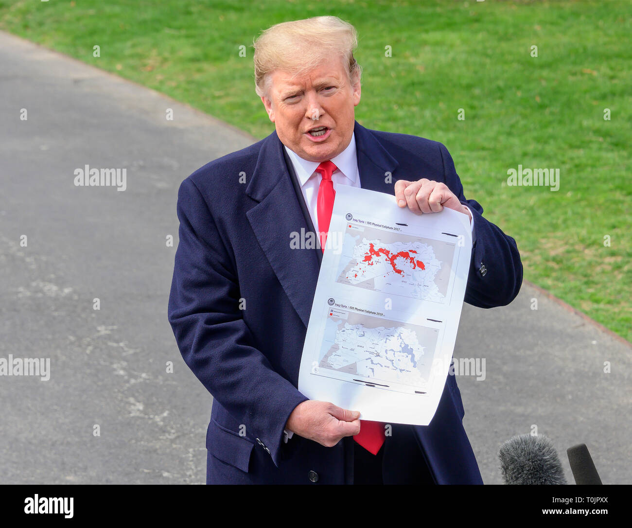 Le Président des Etats-Unis, Donald J. Trump montre une carte montrant le territoire de l'Irak/Syrie "califat physique ISIS 2017' (en haut) "Irak/Syrie ISIS Califat Physique 2019' (en bas) comme il parle aux médias qu'il quitte la pelouse Sud de la Maison Blanche à Washington, DC pour une journée à Lima, Ohio et Canton, Ohio, le mercredi 20 mars, 2019. Credit : Ron Sachs/CNP /MediaPunch Banque D'Images