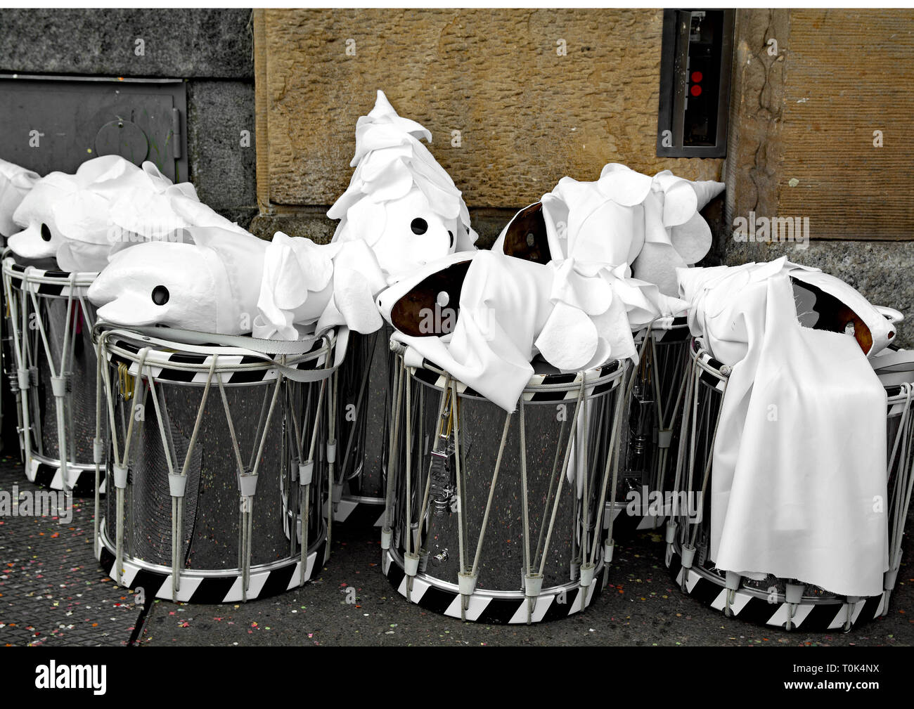 Masques arlequin blanc et d'une batterie à gauche à un coin de rue au cours de la Basel carnival pendant que les participants ont de la pause déjeuner. Banque D'Images