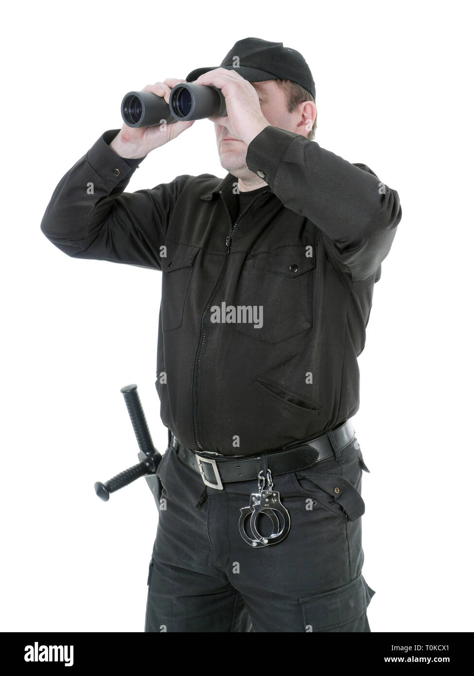 Garde-frontière portant uniforme noir regardant à travers des jumelles, shot on white Banque D'Images