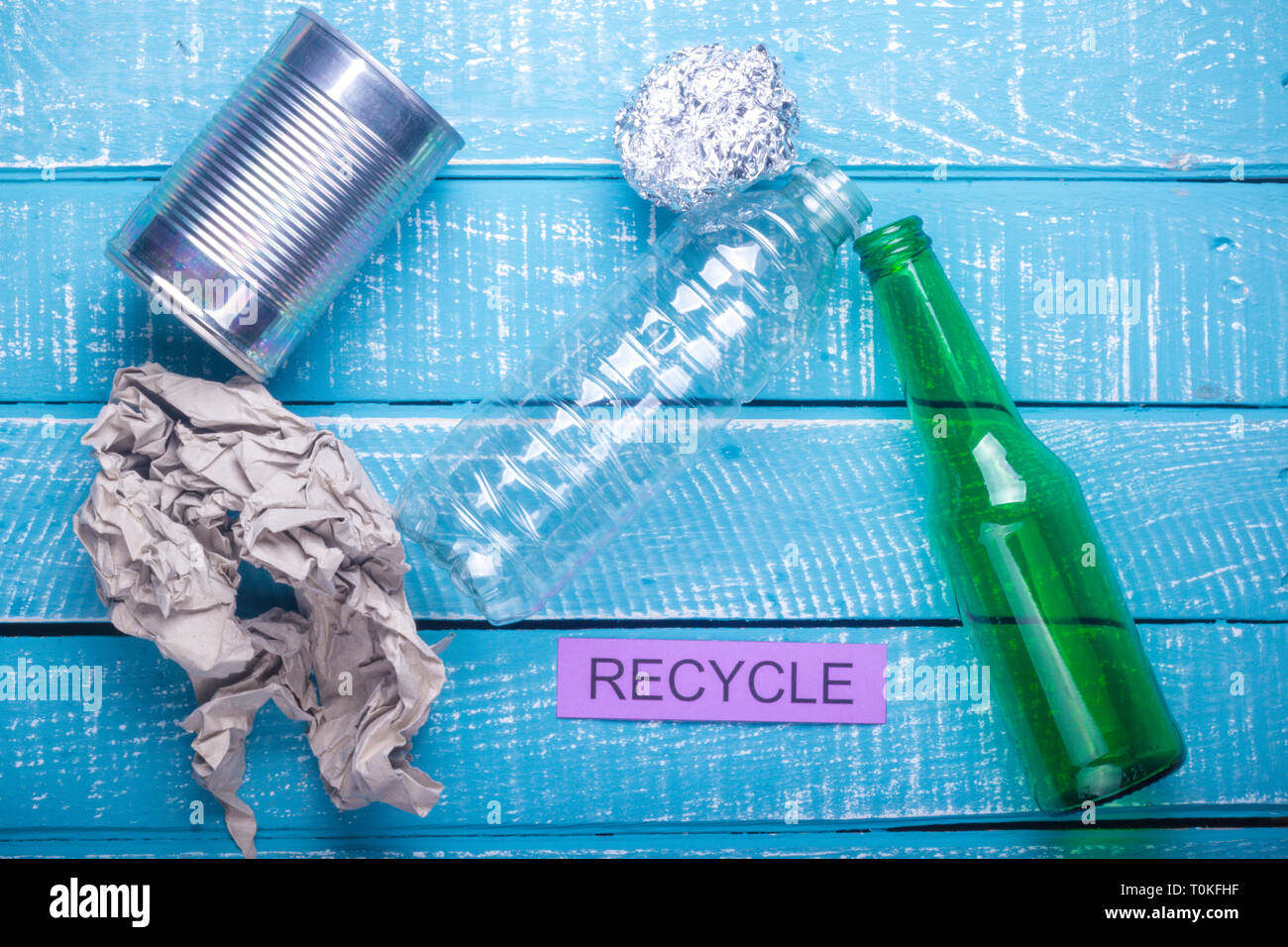 Concept de recyclage de déchets de papier produits montrant, verre,  plastique, papier aluminium et recyclage sur un fond patiné bleu Photo  Stock - Alamy