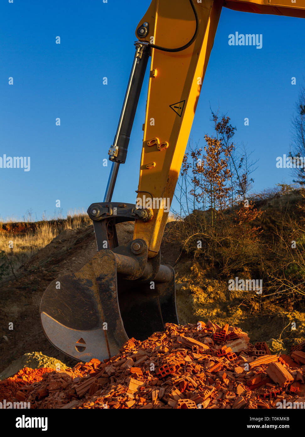 Une grande pelle jaune, sur un site de construction contre un ciel bleu. Banque D'Images