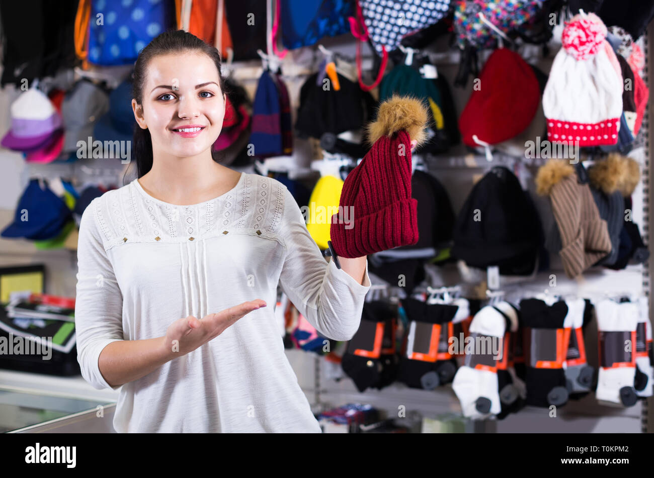 Smiling girl décider sur chapeau chaud dans magasin de sport Banque D'Images