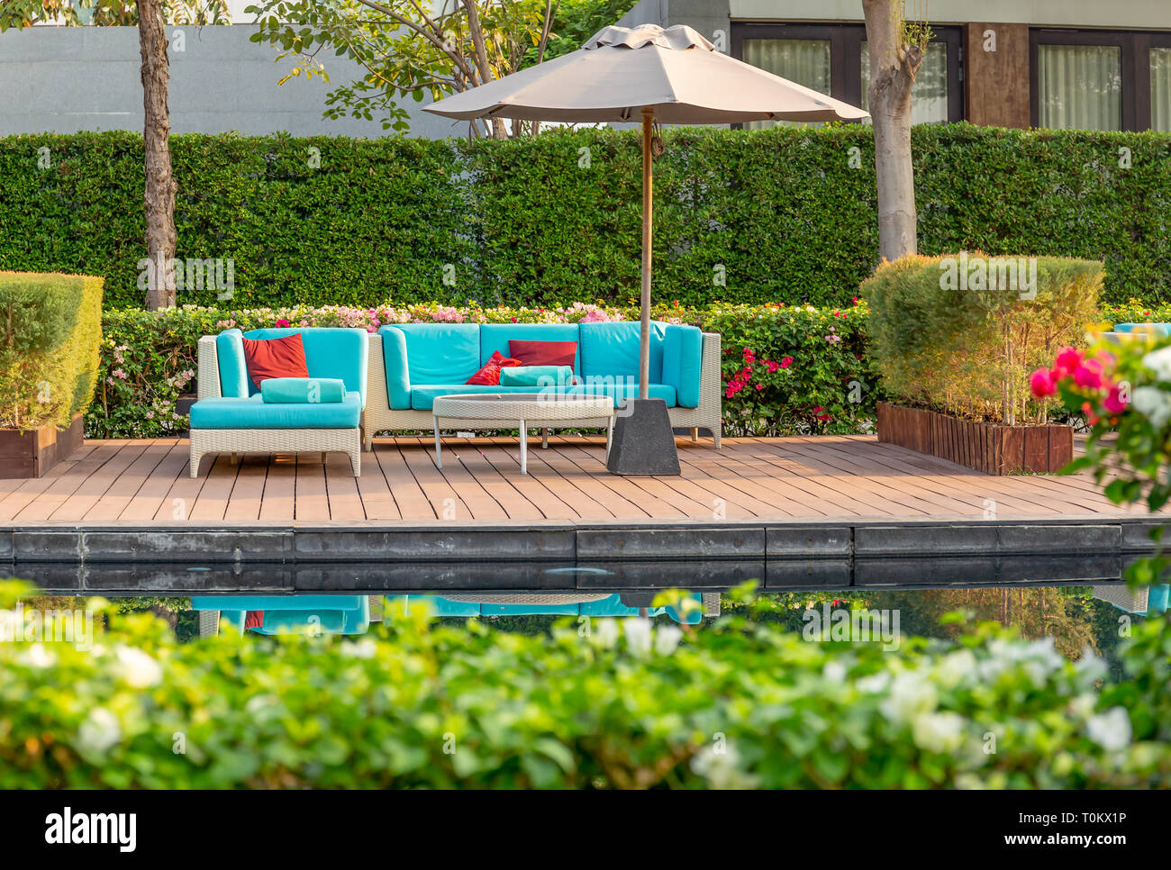 Grande terrasse patio avec des meubles en rotin dans le jardin avec parasol  Photo Stock - Alamy