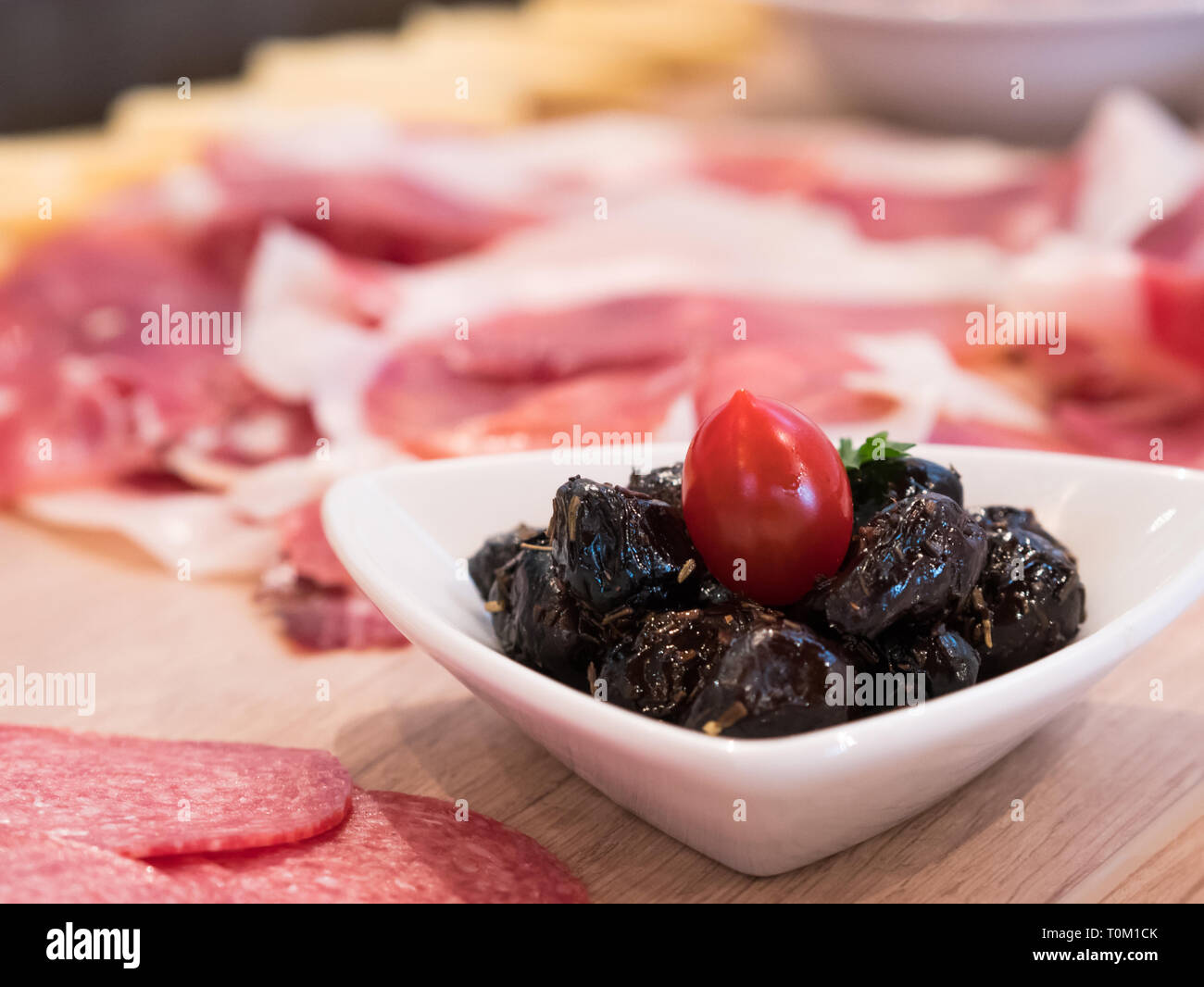 Olives noires au jambon fumé à l'arrière-plan sur table banket Banque D'Images
