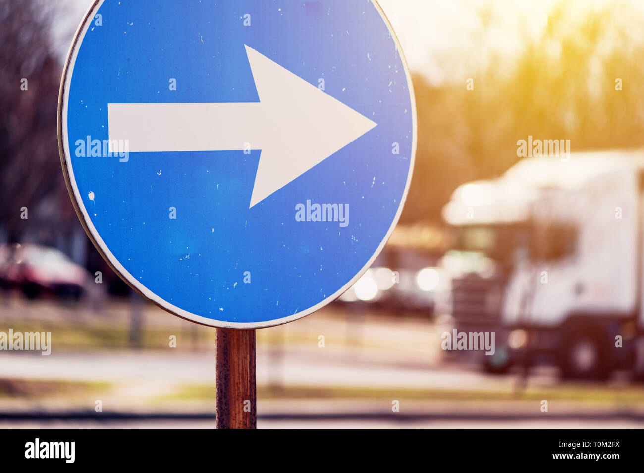 Continuer en direction du trafic flèche signe sur la rue avec véhicule de flou artistique en arrière-plan Banque D'Images