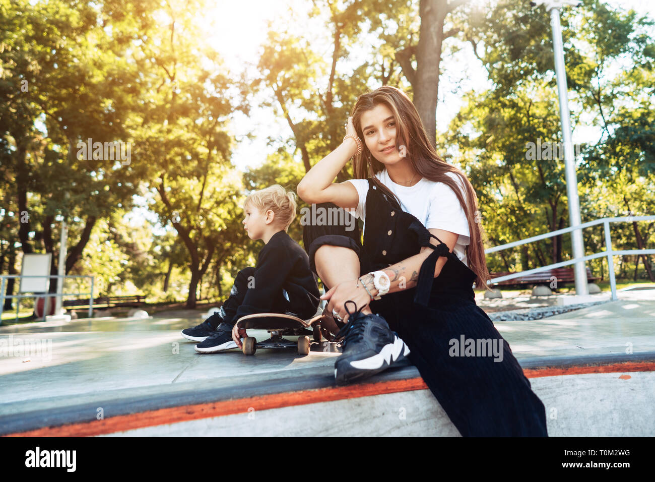 Belle jeune hipster maman et petit fils à l'skatepark Banque D'Images