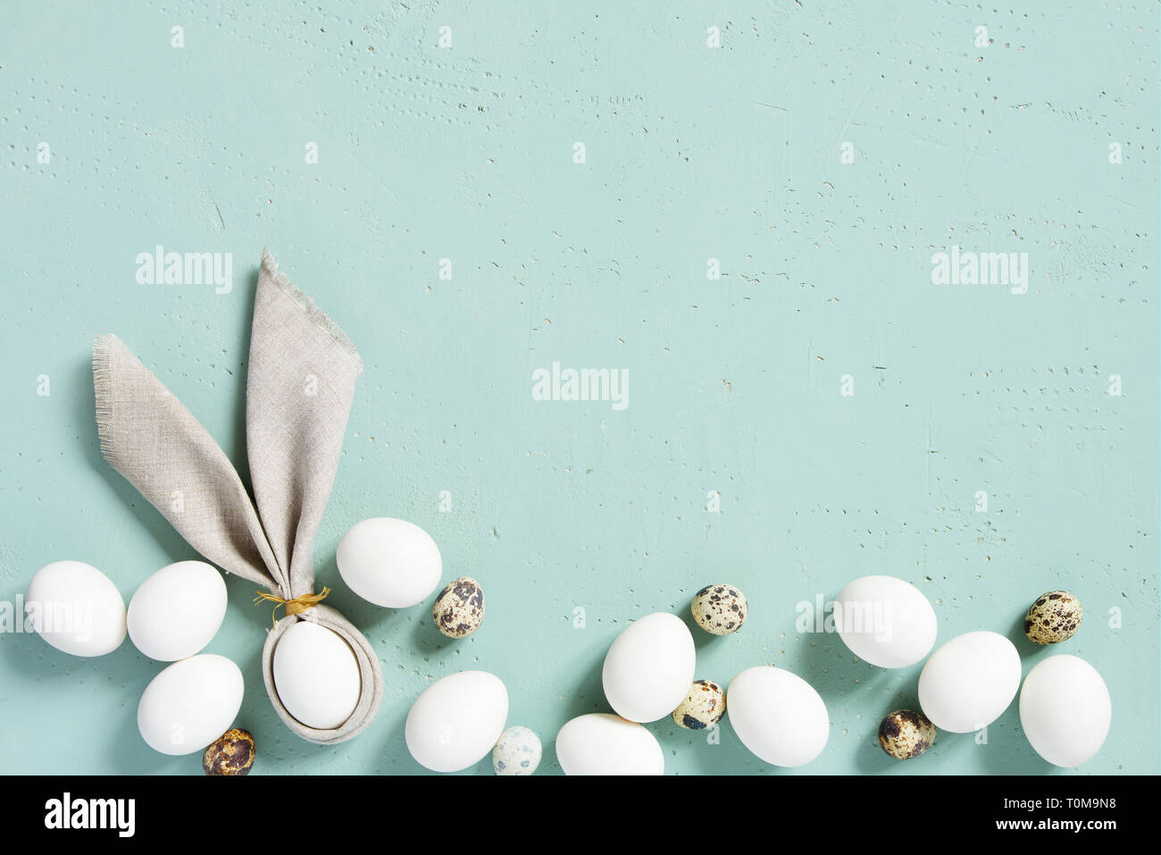 Arrière-plan de pâques avec du poulet et des oeufs de cailles avec oreilles de lapin de linge serviette sur la table, texturé bleu Vue de dessus, copy space Banque D'Images