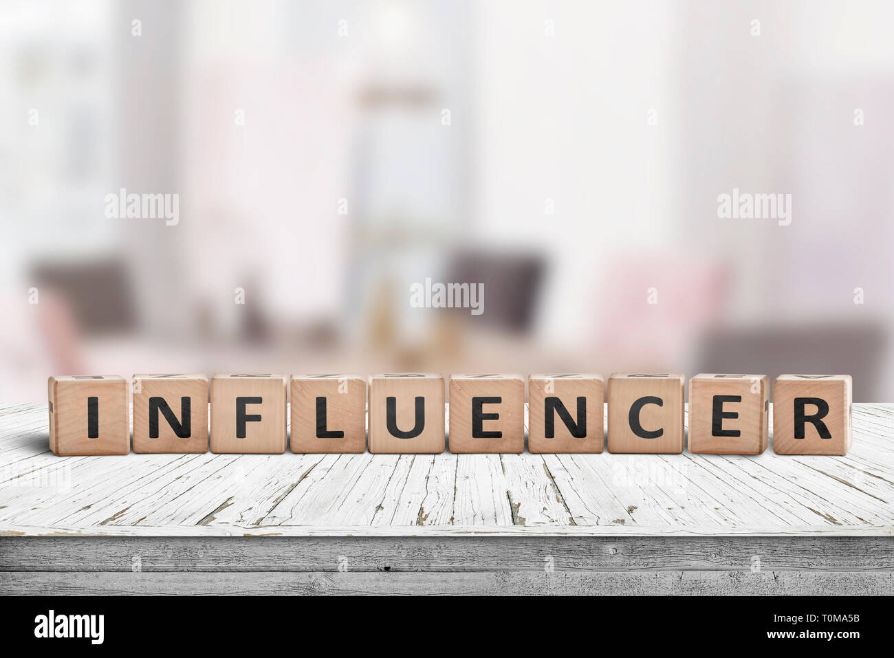 Influenceur signe sur une table en bois dans une pièce très lumineuse, d'un blogueur Banque D'Images
