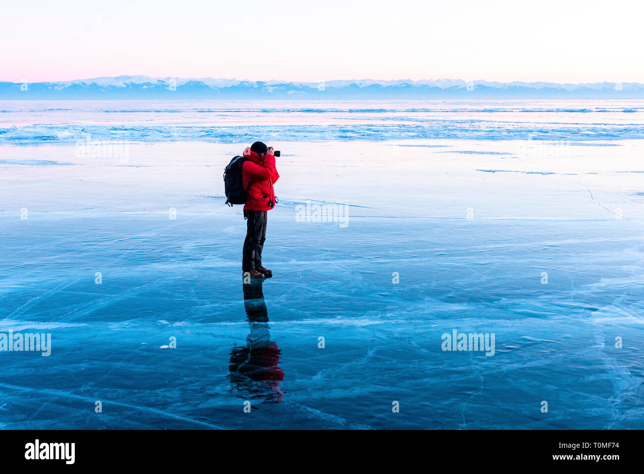 Photographe debout sur lac gelé, Lac Baikal, Sibérie, Russie Banque D'Images