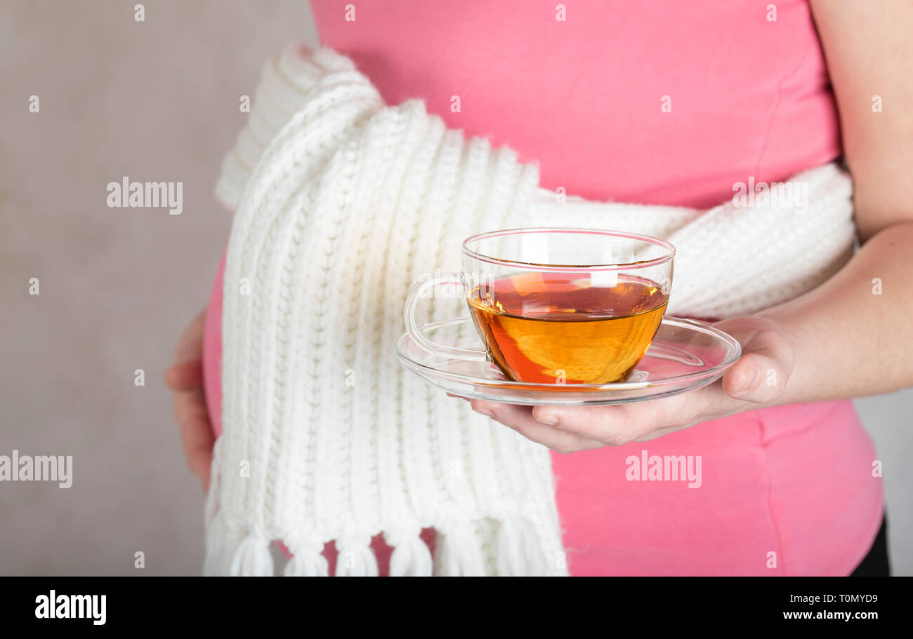 Les jeunes femmes enceintes entre 30 et 35 ans femme conserve la coupe du verre de tisane. Libre Banque D'Images