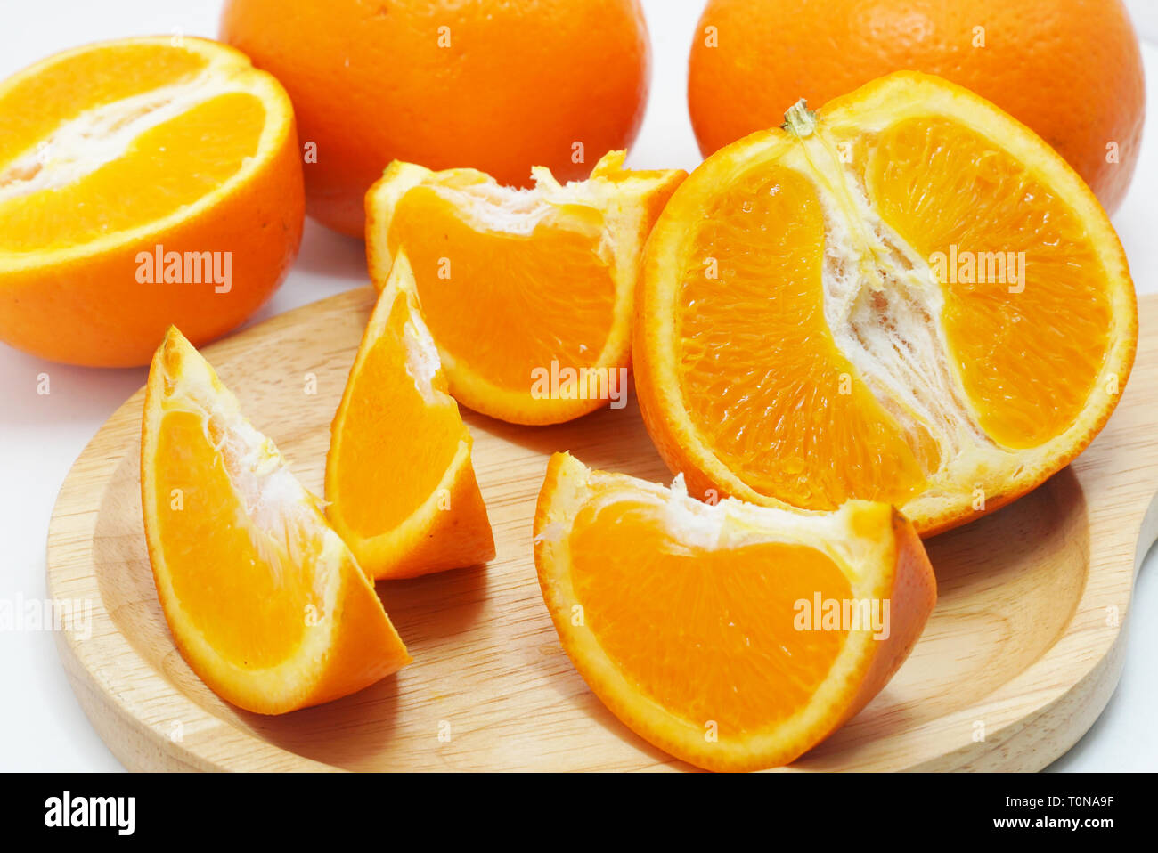 Groupe d'oranges en tranches sur la plaque de bois Banque D'Images