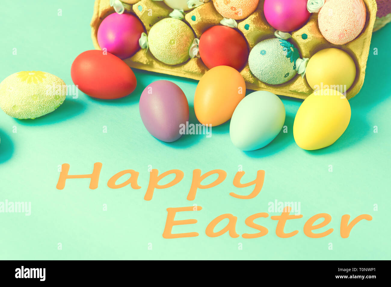 Les oeufs de Pâques lumineuses se trouvent dans une boîte sur un fond bleu Banque D'Images