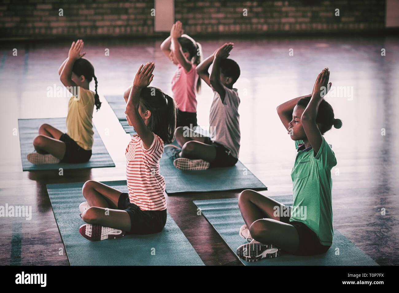 Les enfants de l'école au cours de méditation yoga class Banque D'Images