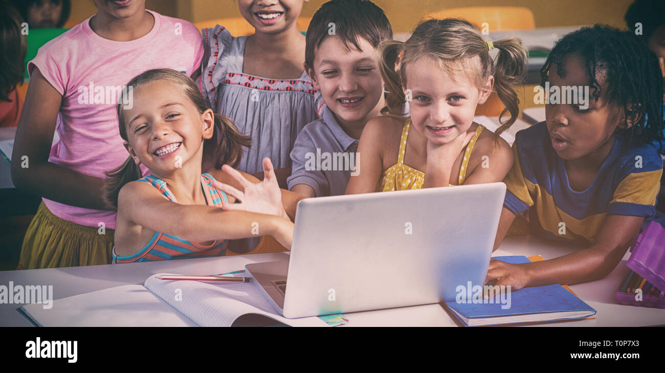 Smiling multi ethnic children using laptop Banque D'Images
