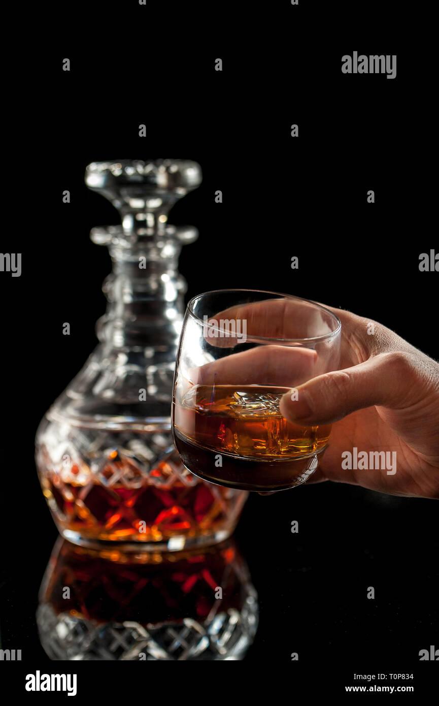 Verre de whisky tenir par la main de l'homme et le cristal carafe sur fond  sombre. Focus sélectif. Copier l'espace Photo Stock - Alamy
