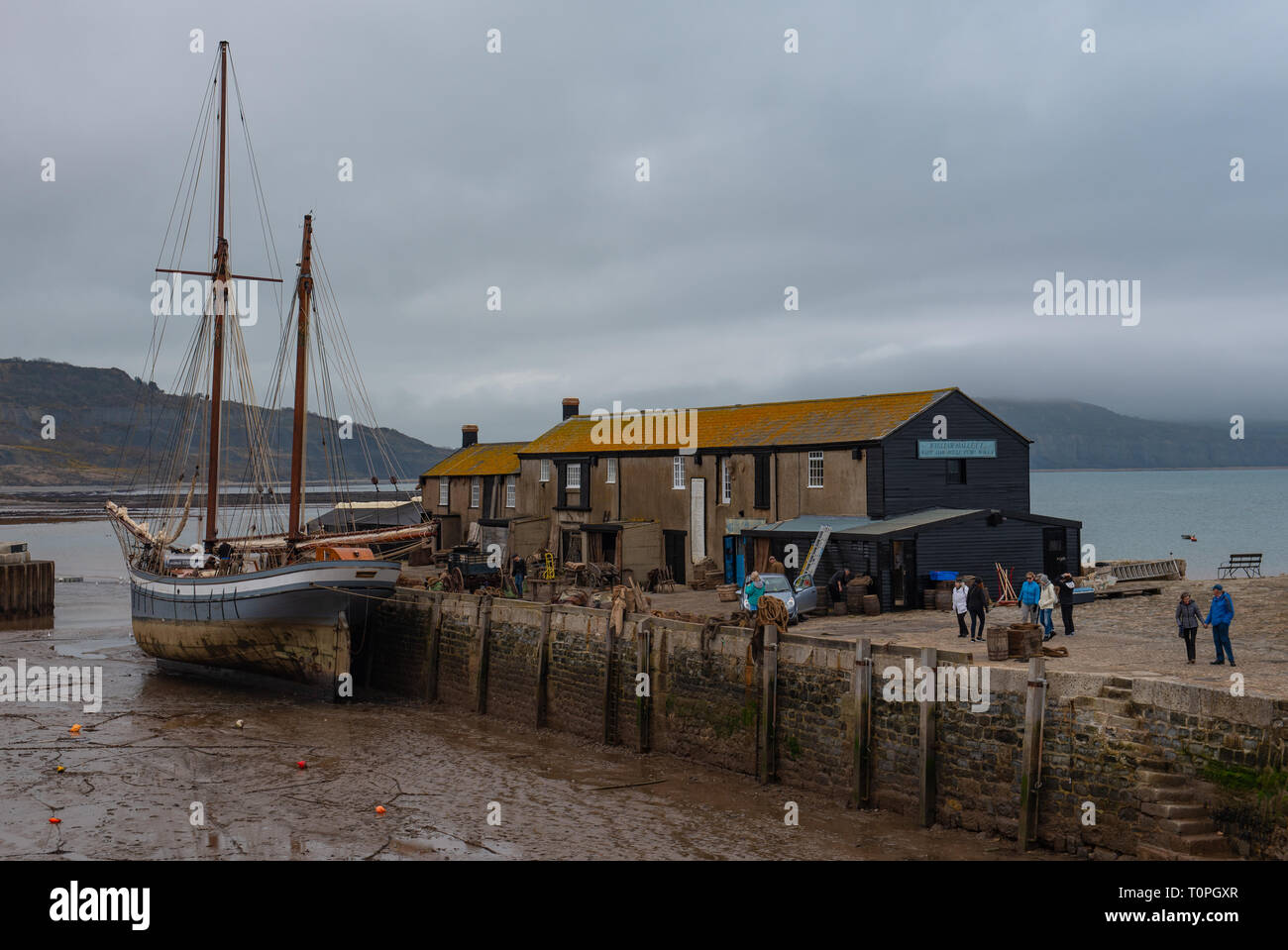 Lyme Regis, dans le Dorset, UK. 21 mars 2019. Navire à voile traditionnelle 1907 'Irene' amarré à Lyme Regis port comme le 100 pied ketch et le Cobb historique bâtiments sont transformés en un décor de cinéma en état de disponibilité pour continué le tournage de Ammonite avec Kate Winslet et Saoirse Ronan. Réalisé par Francis Lee, la fiction dramatique dépeint célèbre chasseur de fossiles que Mary Anning femme gay suscitant des débats entre les historiens et sur les médias sociaux. Le film est prévu d'apporter un coup de pouce pour le tourisme et l'économie locale. Credit : Celia McMahon/Alamy Live News Banque D'Images