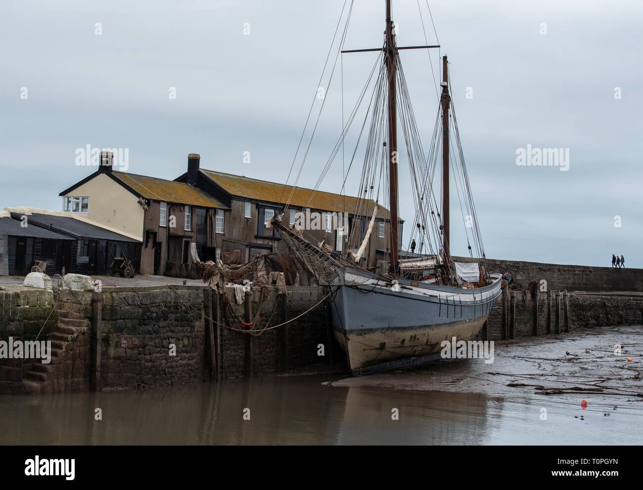 Lyme Regis, dans le Dorset, UK. 21 mars 2019. Navire à voile traditionnelle 1907 'Irene' amarré à Lyme Regis port comme le 100 pied ketch et le Cobb historique bâtiments sont transformés en un décor de cinéma en état de disponibilité pour continué le tournage de Ammonite avec Kate Winslet et Saoirse Ronan. Réalisé par Francis Lee, la fiction dramatique dépeint célèbre chasseur de fossiles que Mary Anning femme gay suscitant des débats entre les historiens et sur les médias sociaux. Le film est prévu d'apporter un coup de pouce pour le tourisme et l'économie locale. Credit : Celia McMahon/Alamy Live News Banque D'Images
