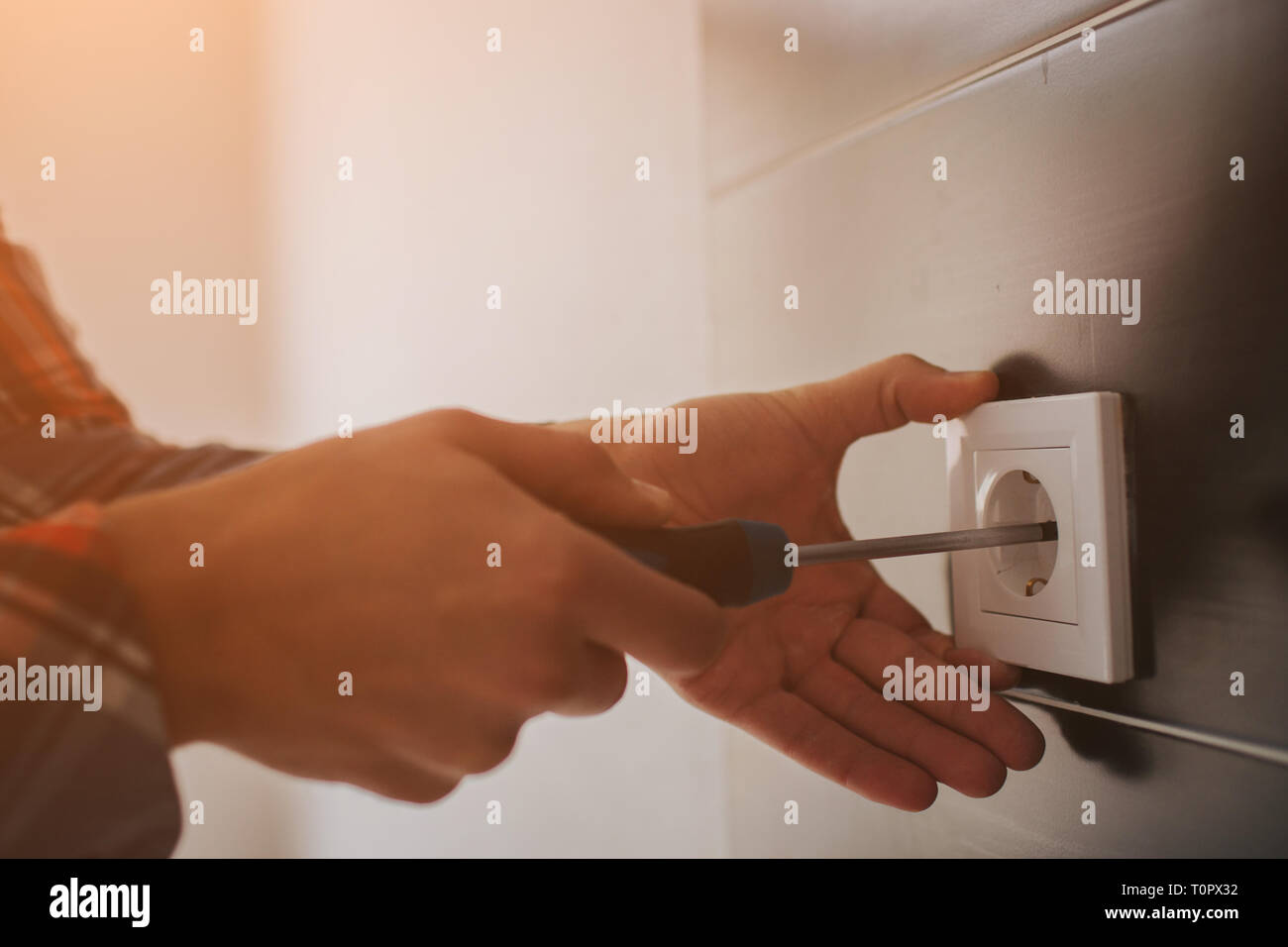 , Électricien d'installer un nouveau socket en cours avec un tournevis. L'installation de prise électrique ou socket : gros plan sur les mains d'électricien. Banque D'Images