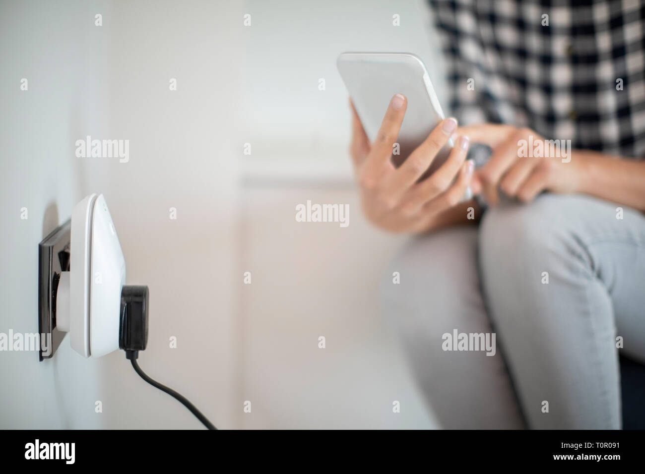 Le contrôle des femme Smart Plug à l'aide de l'App sur téléphone mobile Banque D'Images