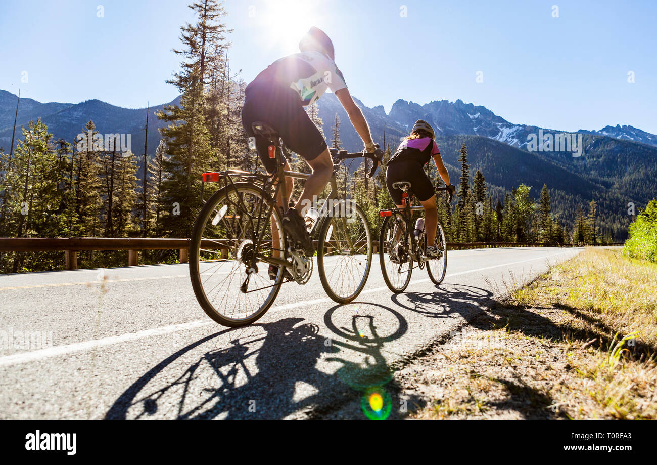 Un jeune couple riding leur vélo jusqu'au col de Washington North Cascades de l'État de Washington, USA. Banque D'Images