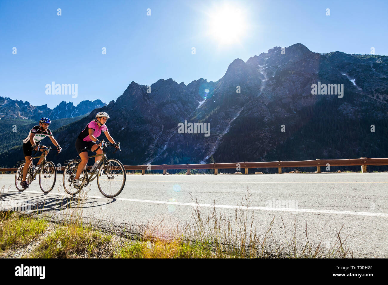 Un jeune couple riding leur vélo jusqu'au col de Washington North Cascades de l'État de Washington, USA. Banque D'Images