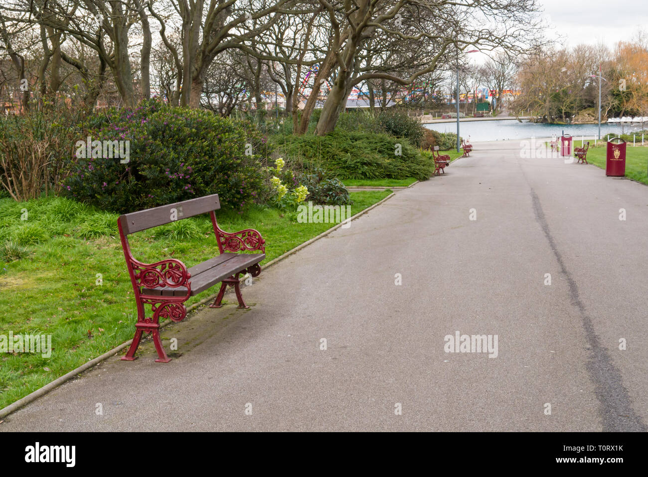 Un banc sur une voie menant au lac au parc marin du Sud, South Shields Banque D'Images