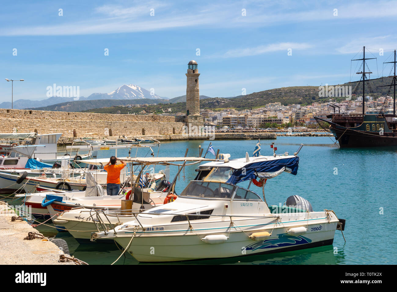 Crète, Grèce - 1 mai 2015 : bateaux de pêche au port de Réthymnon avec phare en arrière-plan. L'île de Crète, Grèce, Europe Banque D'Images
