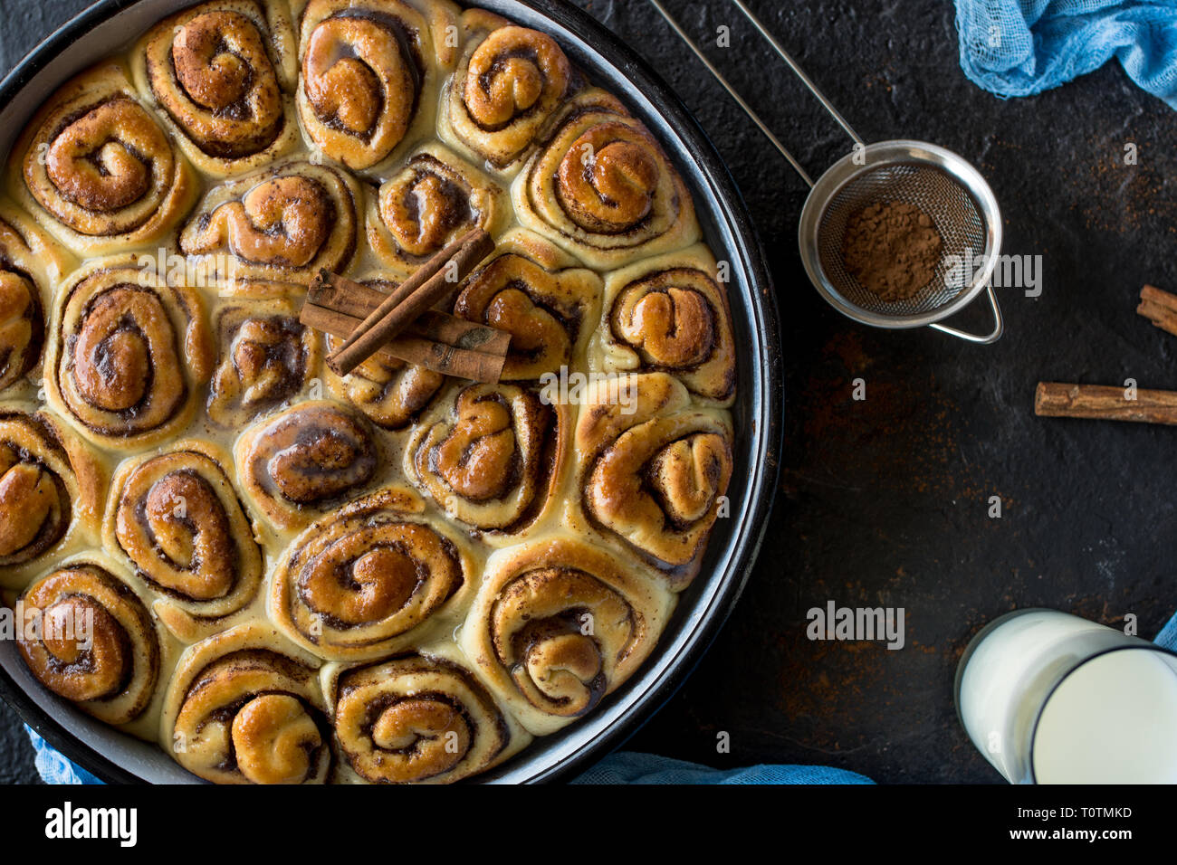 Tarte à la cannelle avec du sirop de sucre dans la casserole de vintage sur fond noir Banque D'Images
