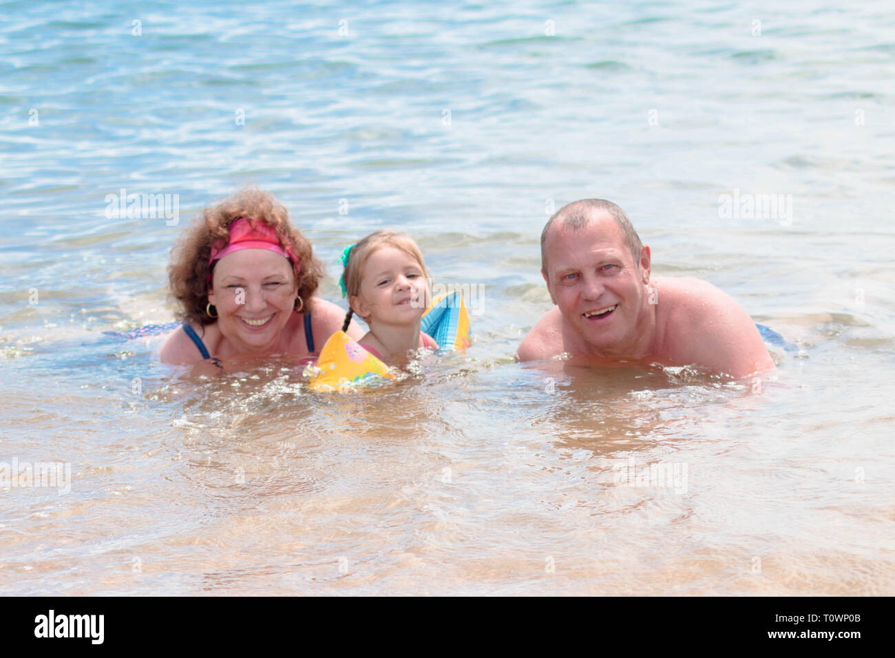 Les grands-parents et petite-fille de nager dans la mer, ils sourient et la bonne humeur. Banque D'Images