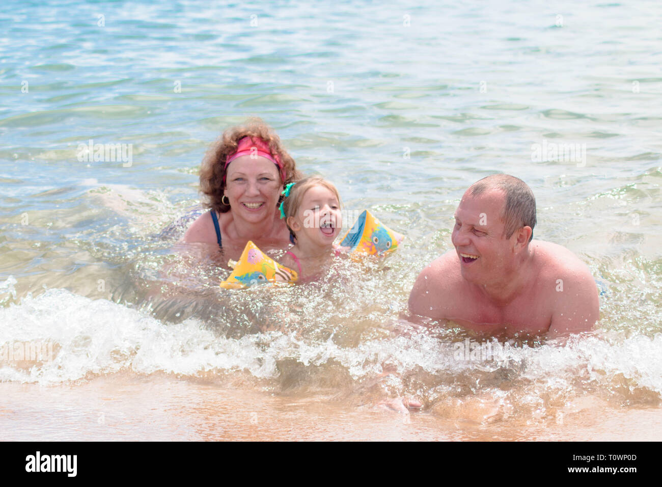 Les grands-parents et petite-fille de nager dans la mer, ils sourient et la bonne humeur. Banque D'Images