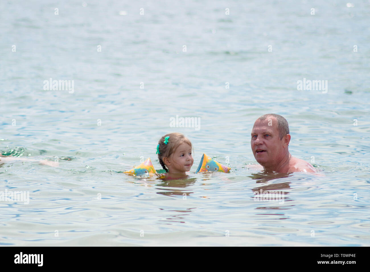 Les grands-parents et petite-fille de nager dans la mer, ils sourient et la bonne humeur. Banque D'Images