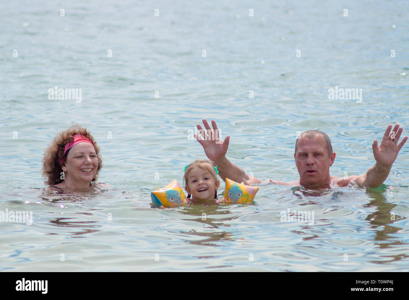 Les grands-parents et petite-fille de nager dans la mer, ils sourient et la bonne humeur. Banque D'Images