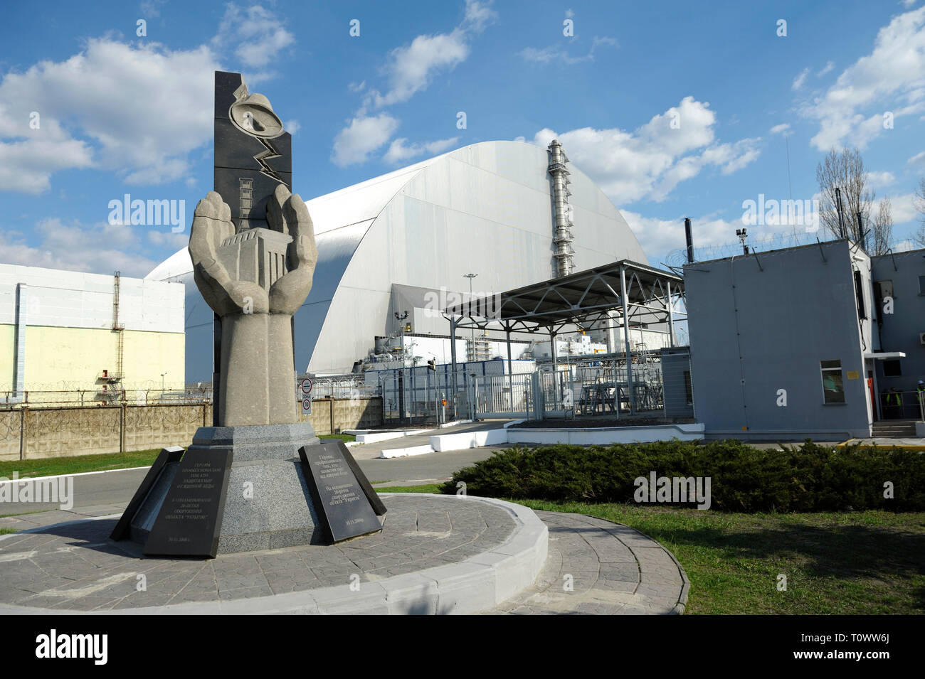 Monument aux liquidateurs de Tchernobyl et nouveau confinement de sécurité sur un arrière-plan. Le 20 avril 2018. Tchernobyl, Ukraine Banque D'Images