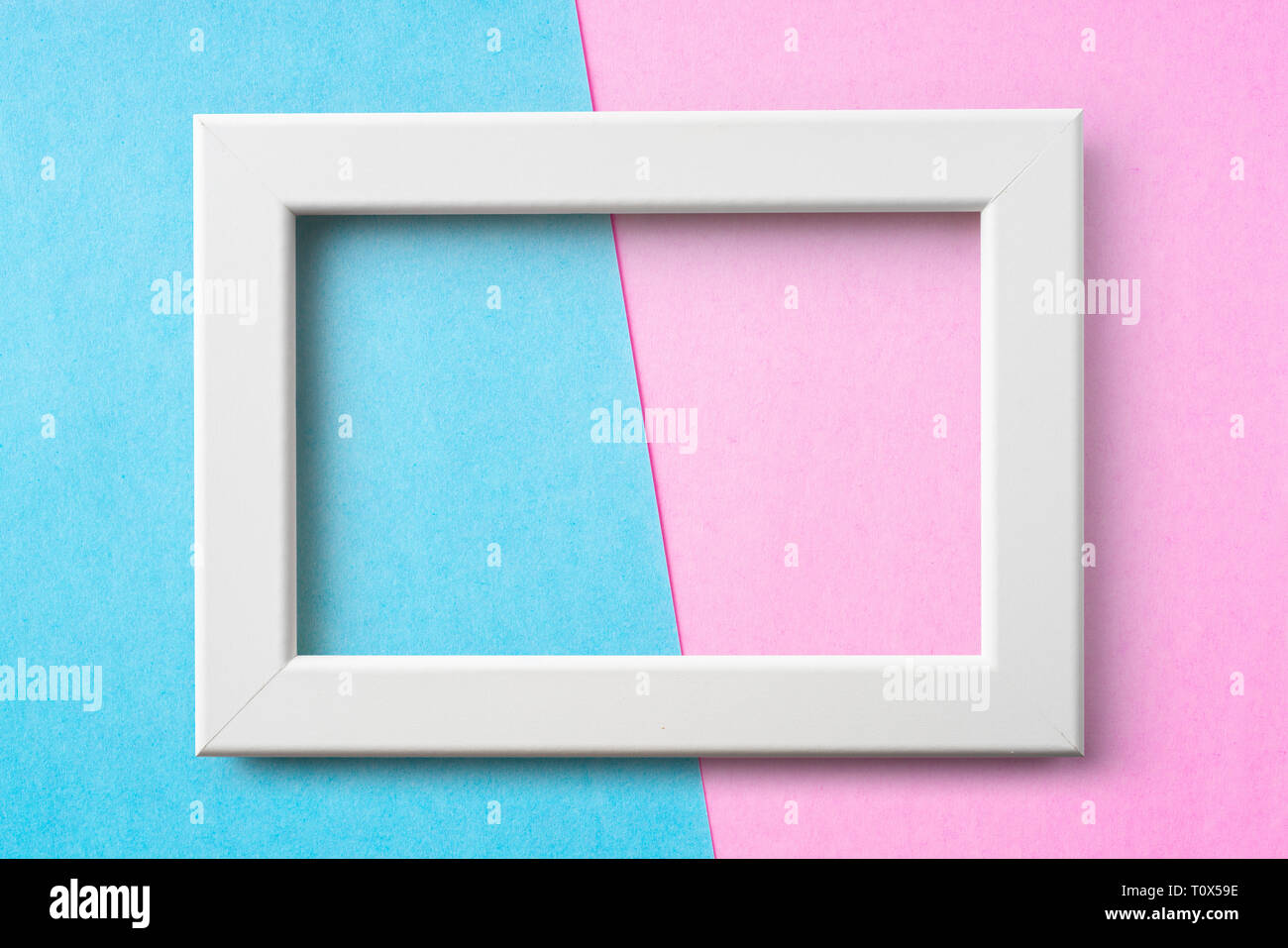Concept Design - cadre en bois blanc sur fond de papier bleu et rose pour une maquette Banque D'Images