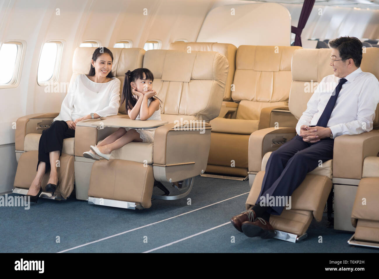 Cute little Girl with grandparents relaxing on airplane Banque D'Images