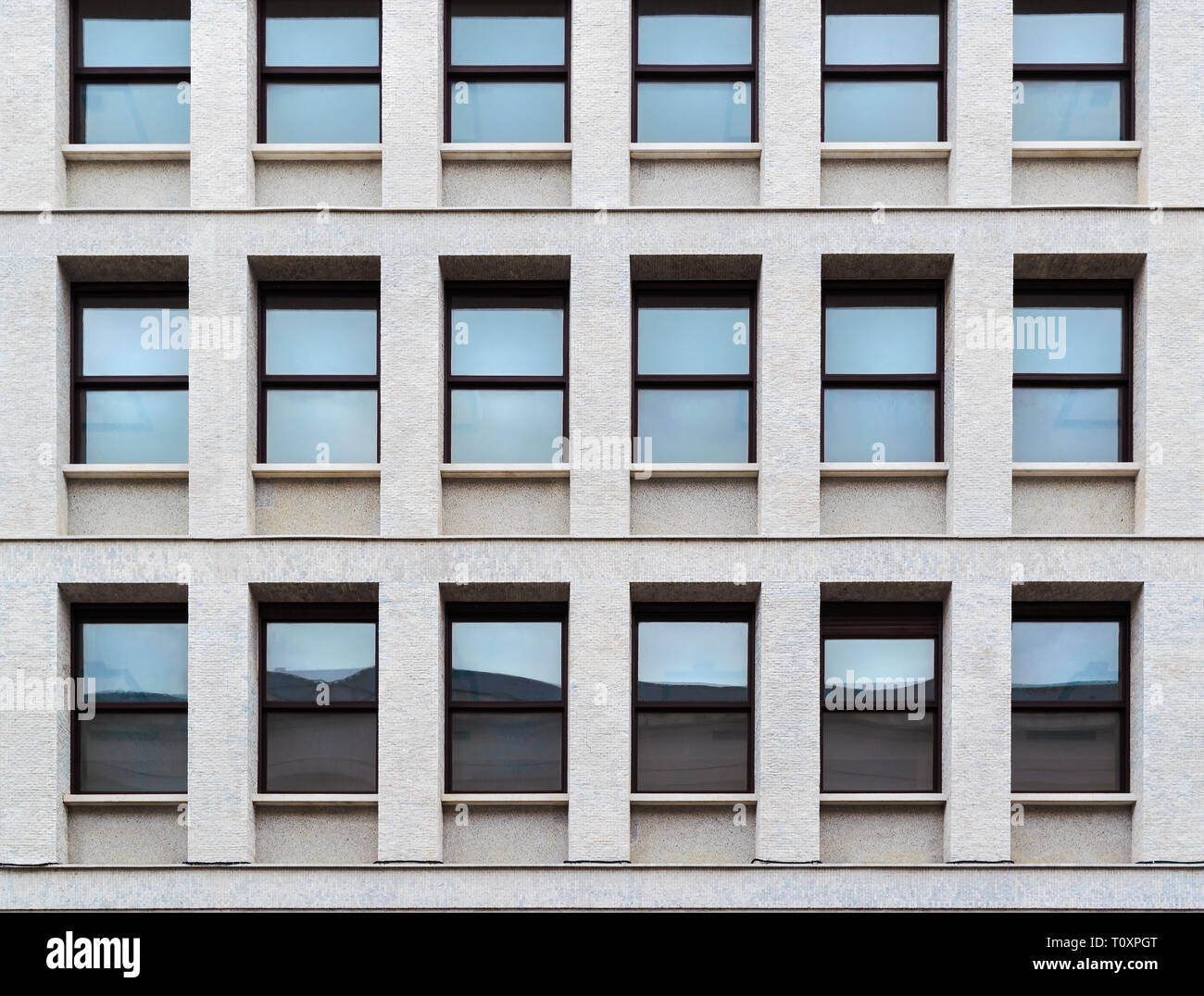 Close-up et la tendance des fenêtres avec du verre bleu, sur la façade d'un bâtiment en pierre moderne, texture Banque D'Images