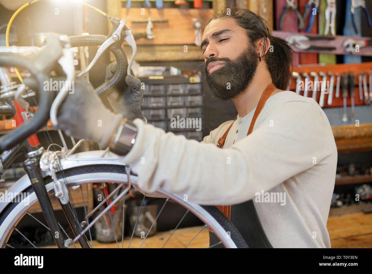 L'homme travaillant en atelier de réparation de vélo Banque D'Images