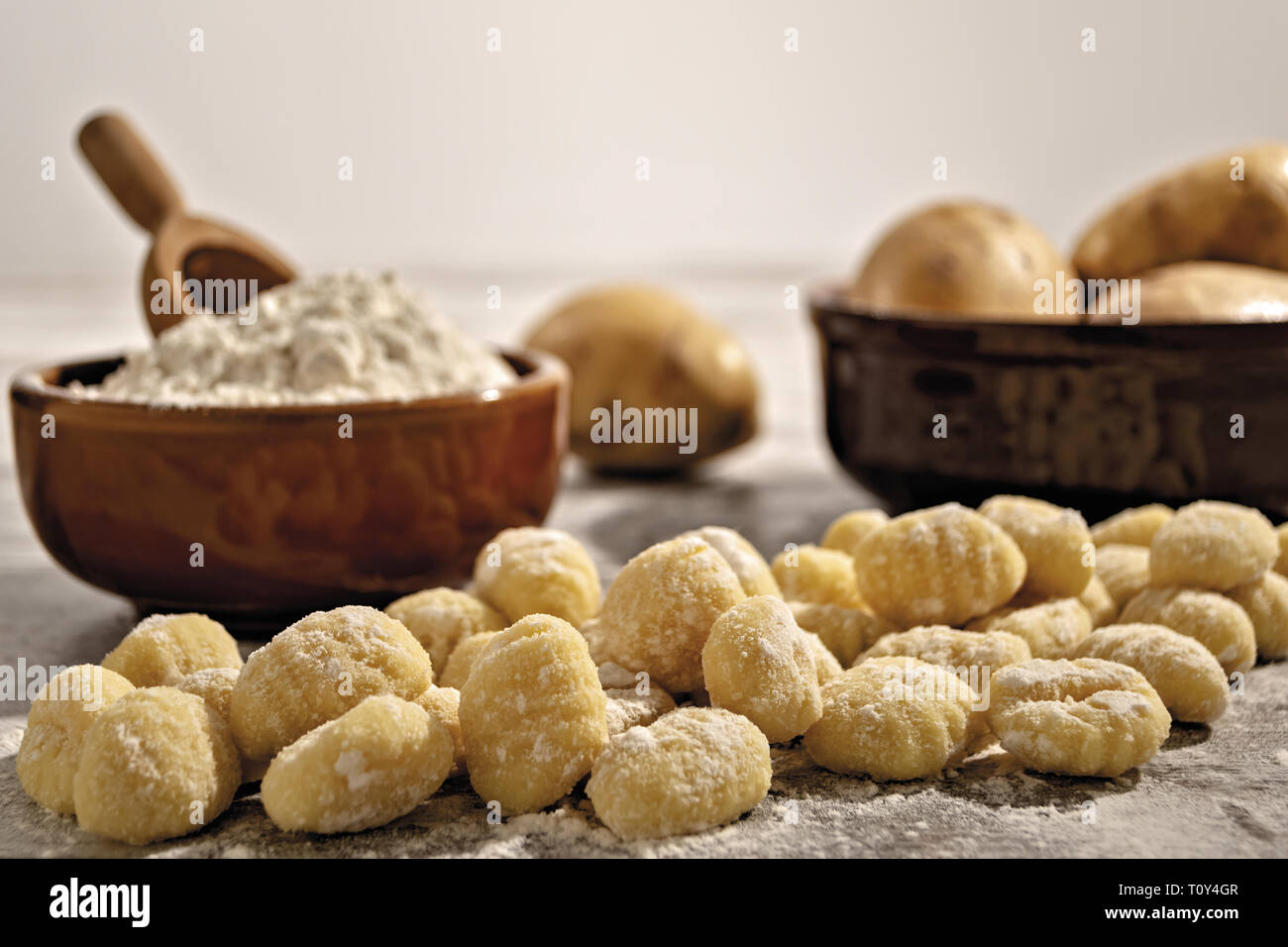 Gnocchi di patate su tavolo rustico con farina e patate fronte Banque D'Images