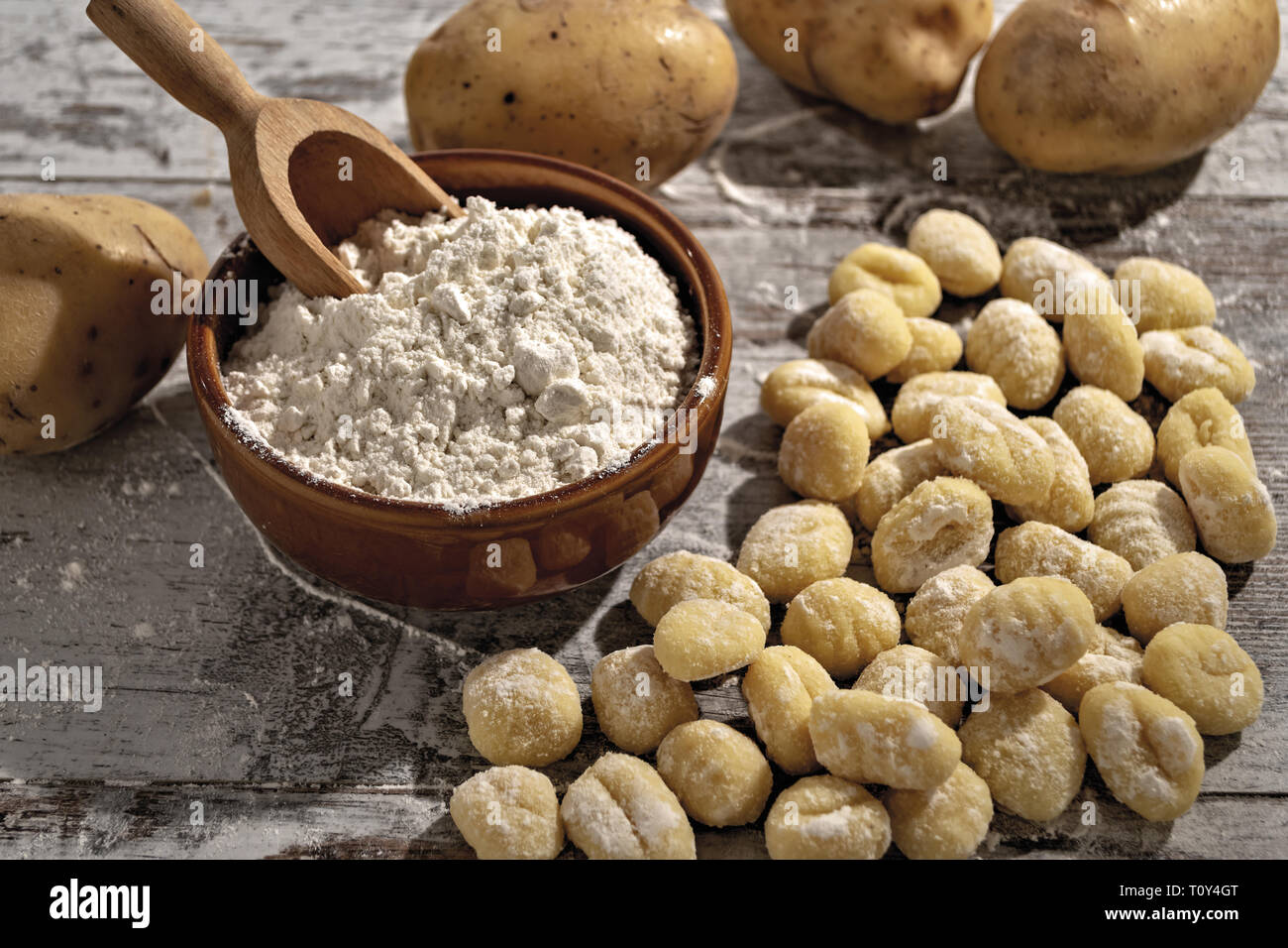 Gnocchi di patate su tavolo rustico con farina e patate dall'alto Banque D'Images