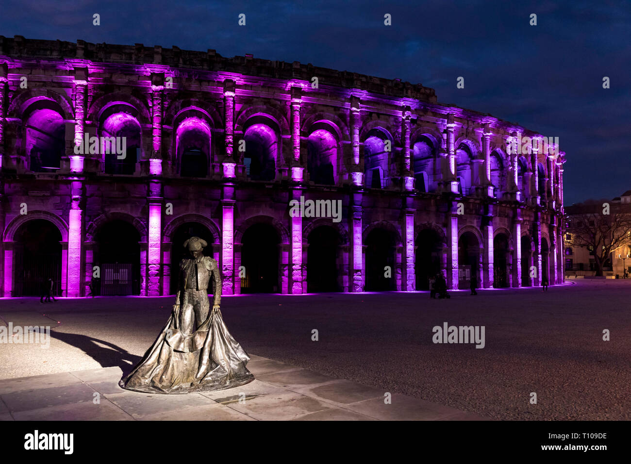 Nîmes (sud-est de la France) : l'arène à la tombée de la nuit avec une statue de Christian Montcouquiol ('Nimeno II') et les lumières de Noël Banque D'Images