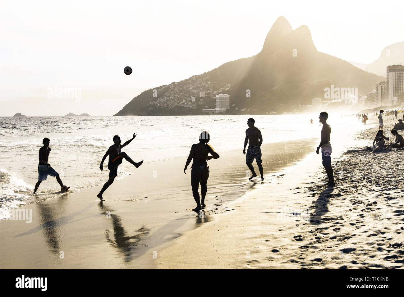 RIO DE JANEIRO, Brésil - 24 février 2015 : un groupe de Brésiliens jouant sur le rivage de la plage d'Ipanema, avec la célèbre montagne Dois Irmãos derrière eux Banque D'Images