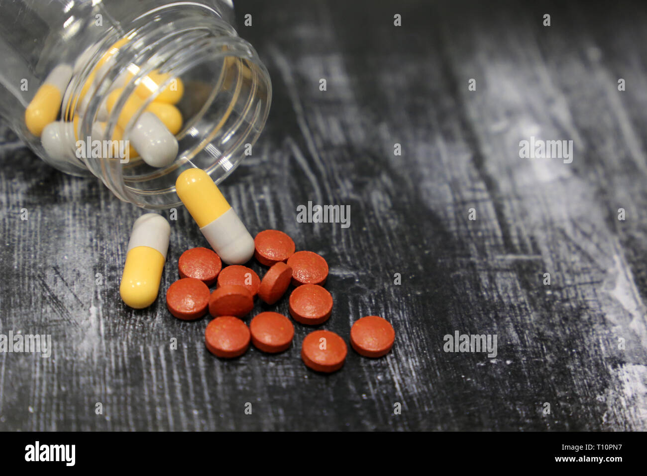 Bouteille de pilules sur la table en bois sombre, de la médecine dans des capsules comprimés close-up. Concept de médicaments, antibiotiques, vitamines, pharmacie Banque D'Images