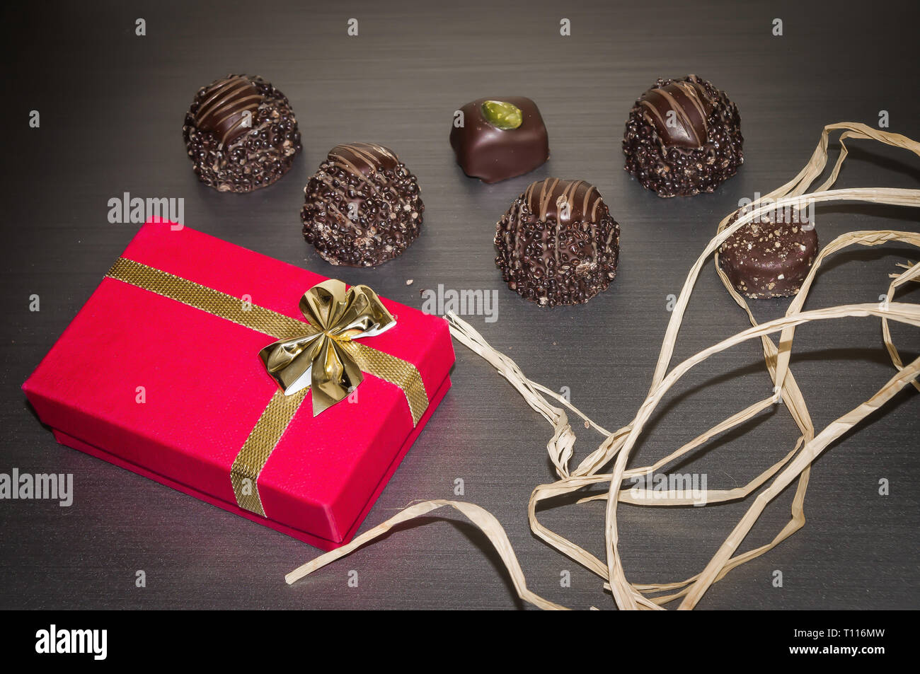 Boîte cadeau en velours rouge avec le cadeau d'anniversaire au chocolat de luxe. Banque D'Images